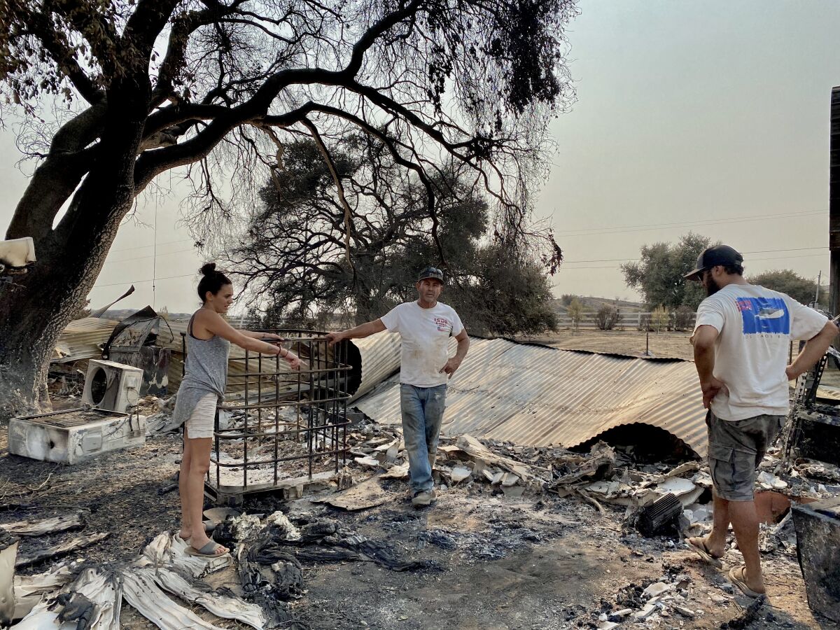 A family surveys damage to its ranch in Jamul, in San Diego County.
