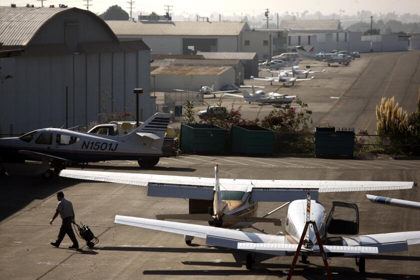 A mechanic walks away from parked planes at Santa Monica Airport. A new legal skirmish has erupted over a proposal ballot measure that would require voters to approve any land use change at the airport.