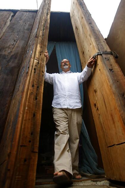 Another component of the home is recycled 100-year-old redwood planks from a bridge in Northern California. The couple bought 200 of the timbers, each 27 feet long and 1 ton, from a salvage yard in Rosarito Beach. They cut the plants and used them to fashion the front door, pictured here, as well as the roof and floor, front walkway, back deck and kitchen table. A steel pivot in the floor allows the 18-foot-tall, half-ton door to move with ease.
