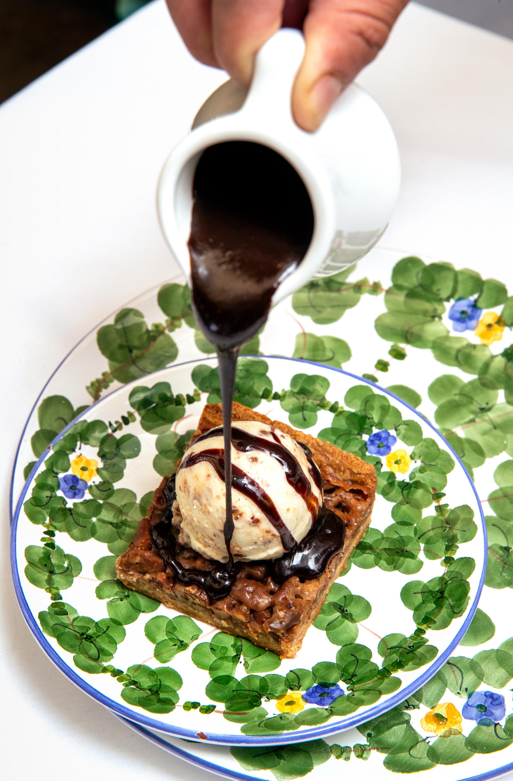 A hot pecan square topped with praline gelato and hot fudge sauce.