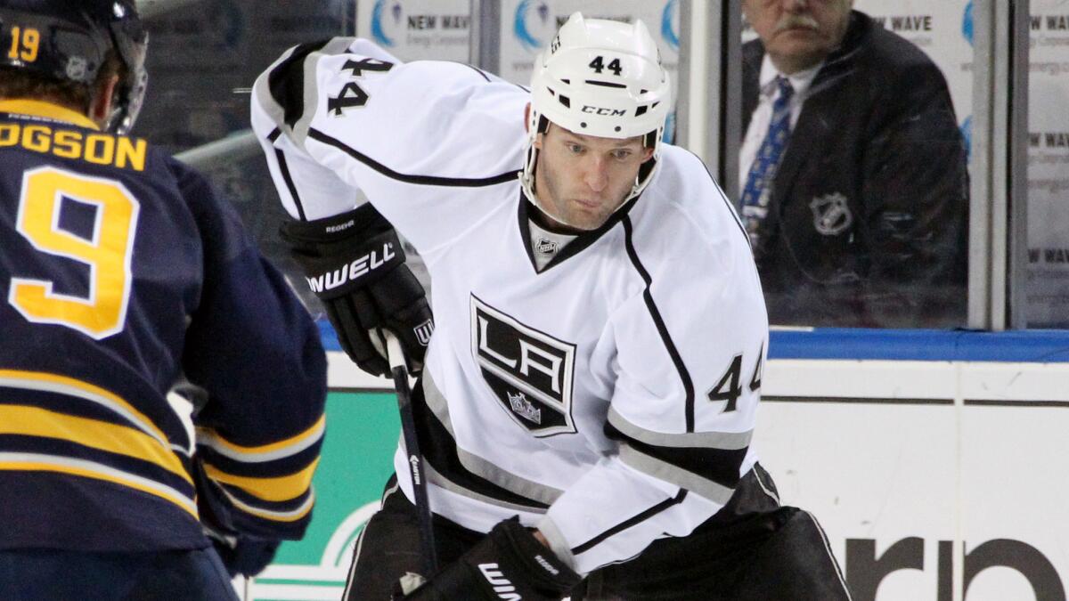 Kings defenseman Robyn Regehr, right, controls the puck during a game against the Buffalo Sabres on Dec. 9.