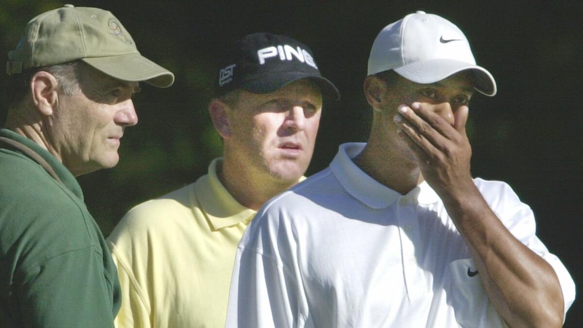 Tiger Woods, right, and Mark Calcavecchia, center, react to the news of terrorists crashing two planes into the World Trade Center.