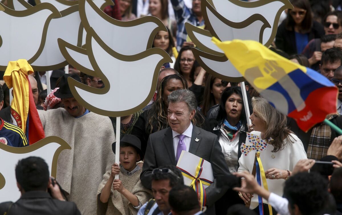 Colombian President Juan Manuel Santos carries a copy of the peace agreement with the Revolutionary Armed Forces of Colombia on his way from the presidential palace to the National Congress in Bogota on Thursday.