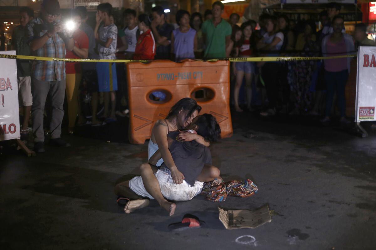 Jennilyn Olayres cradles the dead body of her husband, Michael Siaron, an alleged drug pusher. He was killed by unidentified gunmen in Pasay City south of Manila.