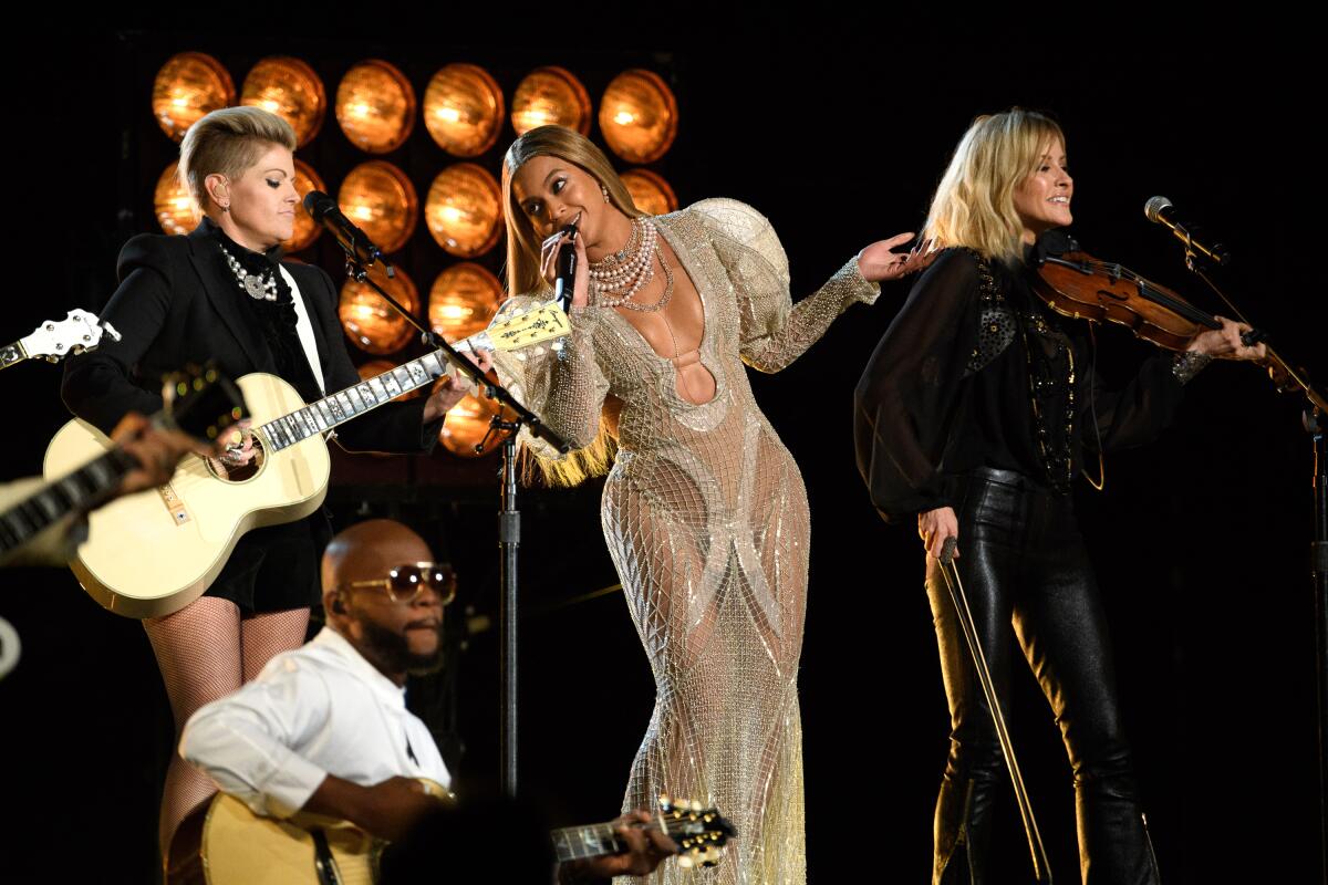 Beyoncé is flanked by the Dixie Chicks at a music awards performance.