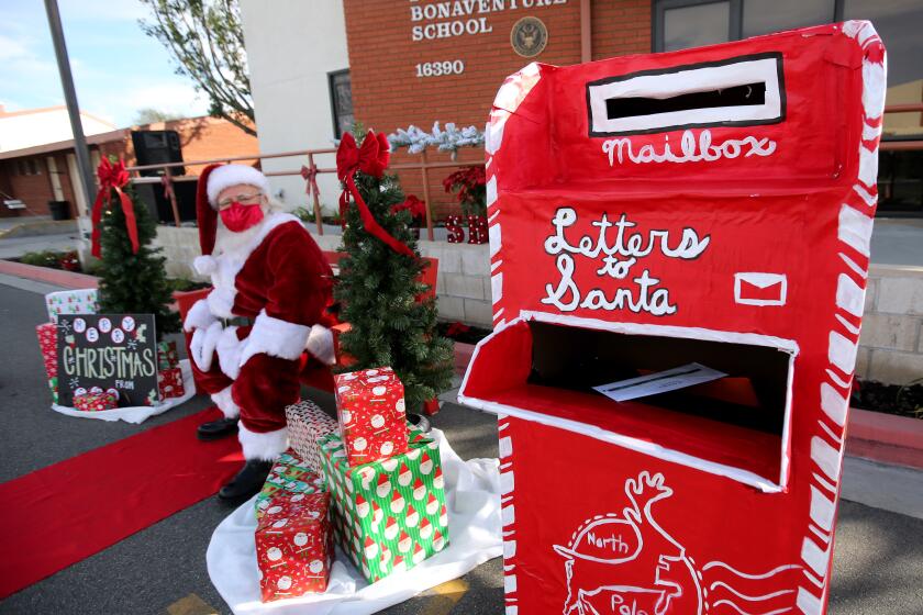 Santa Claus (Lou Martinez) brought his large mailbox for letters from children during the St. Bonaventure Catholic School Santa Drive-Thru Experience, at the campus in Huntington Beach on Saturday, Dec. 5, 2020.. Some children also brought letters for Santa, which he dropped into his giant mailbox.