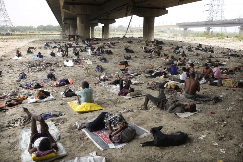 Personas sin casa duermen a la sombra de un puente el viernes 20 de mayo de 2022 para refrescarse 