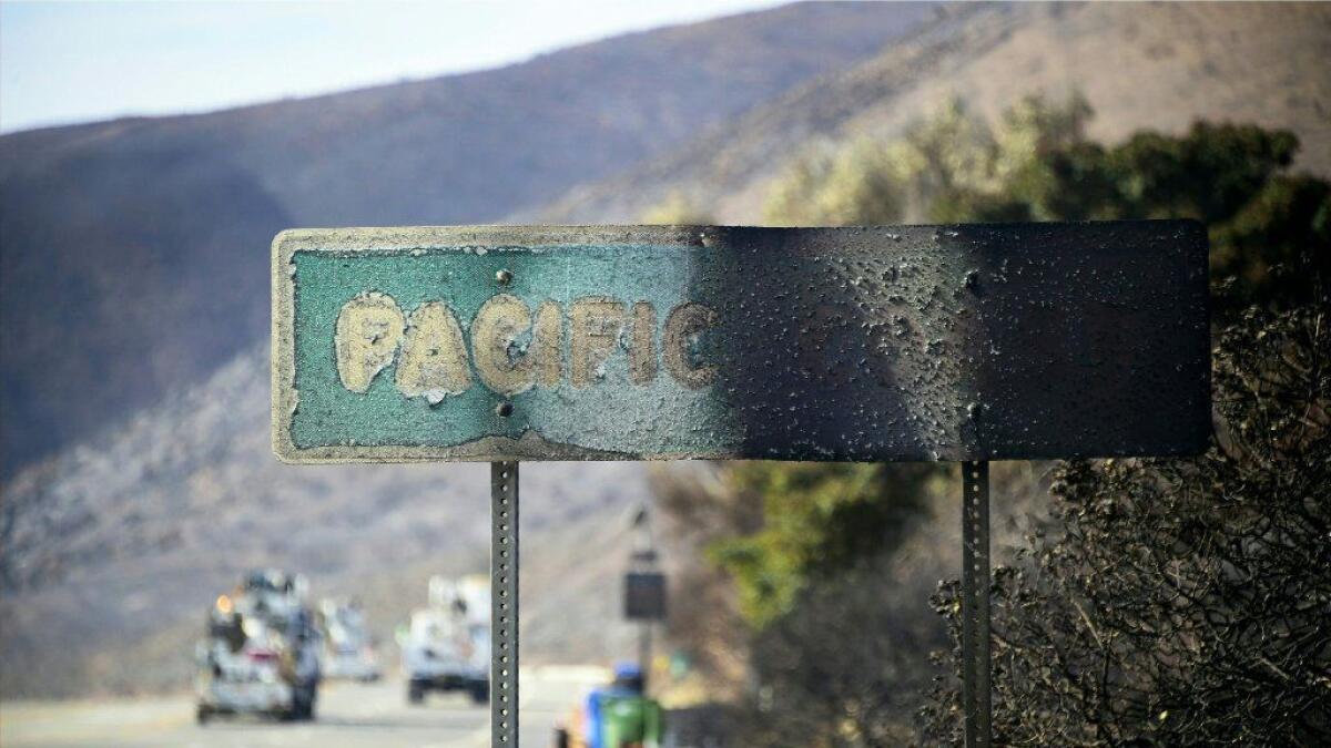 A fire-damaged Pacific Coast Highway sign remains amid the blackened hills in Malibu on Nov. 15.