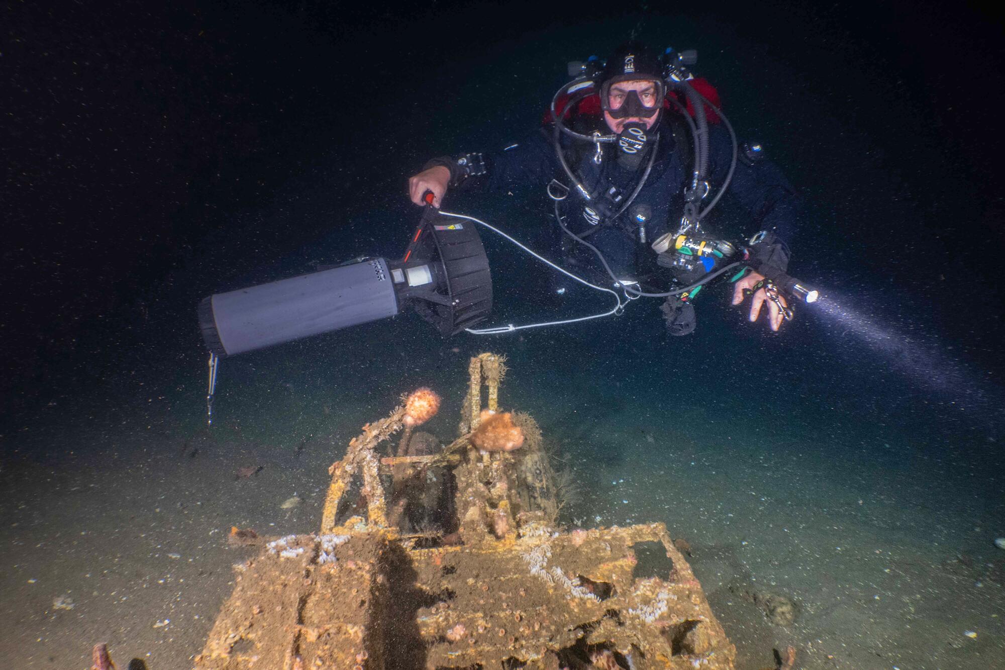 Tyler Stalter and the wreckage of a Navy SH-3A helicopter 