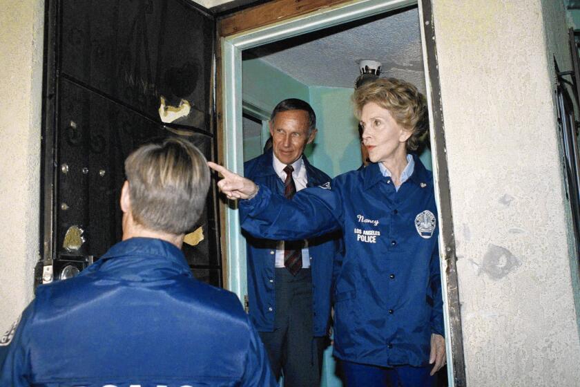 Nancy Reagan came to L.A. in 1989 to boost her image as an anti-drug crusader. Above, she counts the bullet holes in the front door of a suspected "rock house" in South L.A.