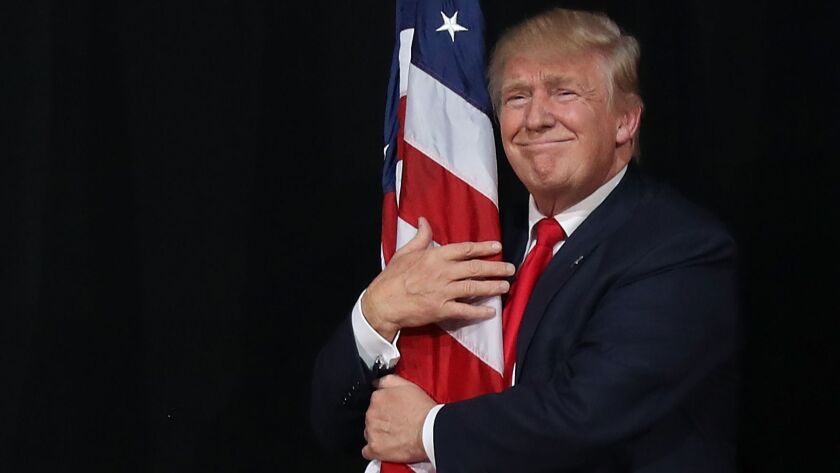 President Trump hugs the American flag at a campaign rally in Tampa, Fla., during the 2016 election.