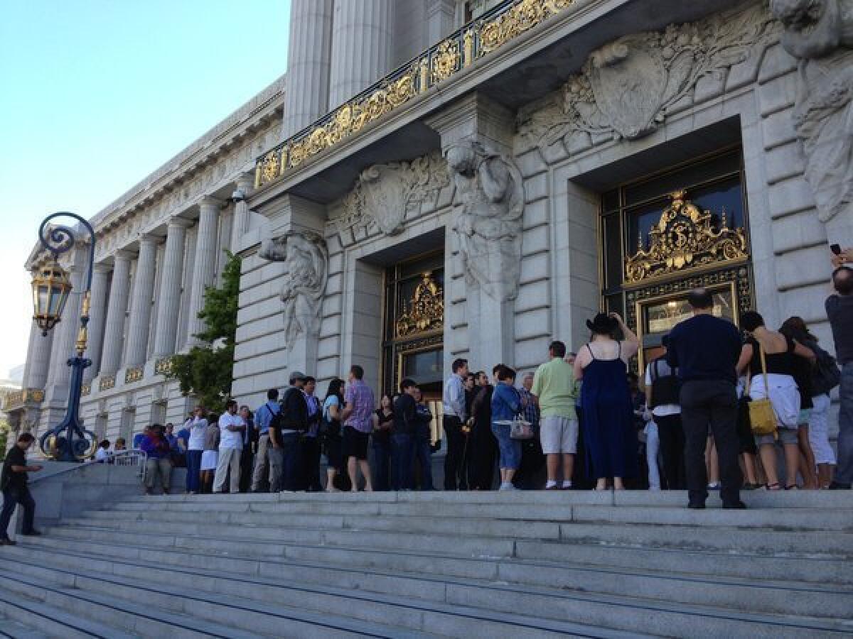 Dozens of same-sex couples line up outside San Francisco City Hall to get married.