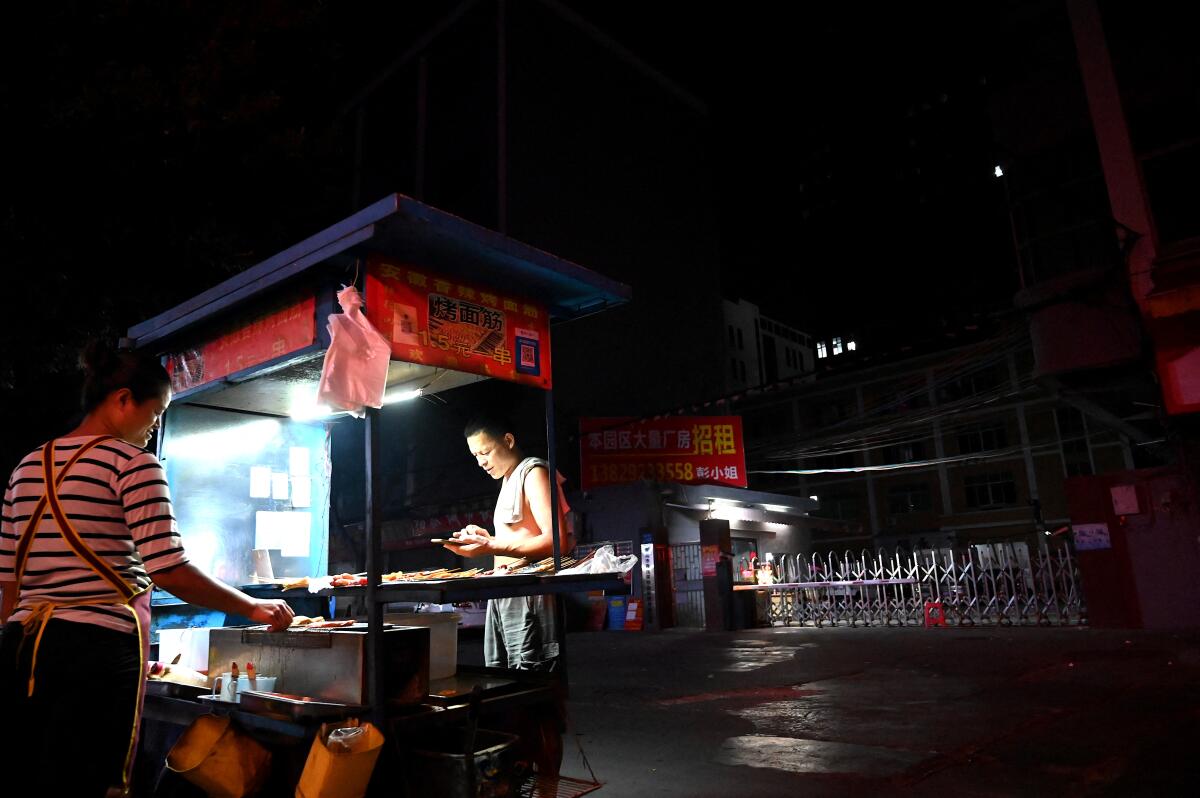 An outdoor barbecue stand at night