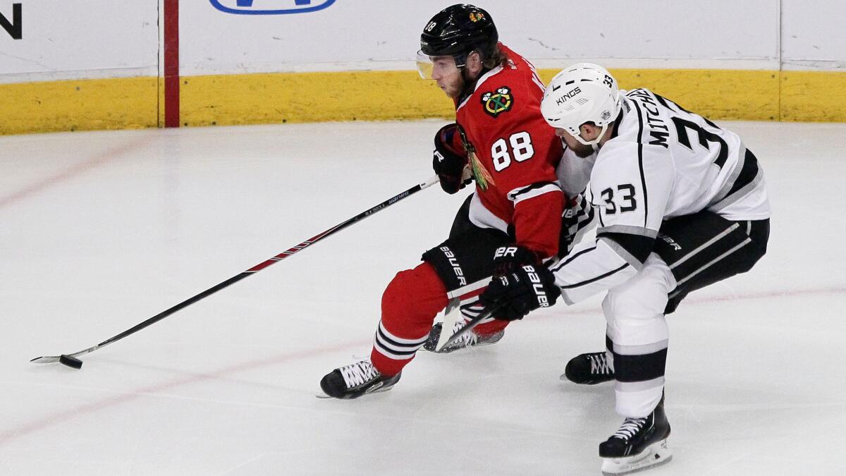 Chicago Blackhawks forward Patrick Kane controls the puck ahead of Kings defenseman Willie Mitchell during Game 2 of the Western Conference finals on Wednesday. Kane has yet to make an impact on the scoresheet in the series.