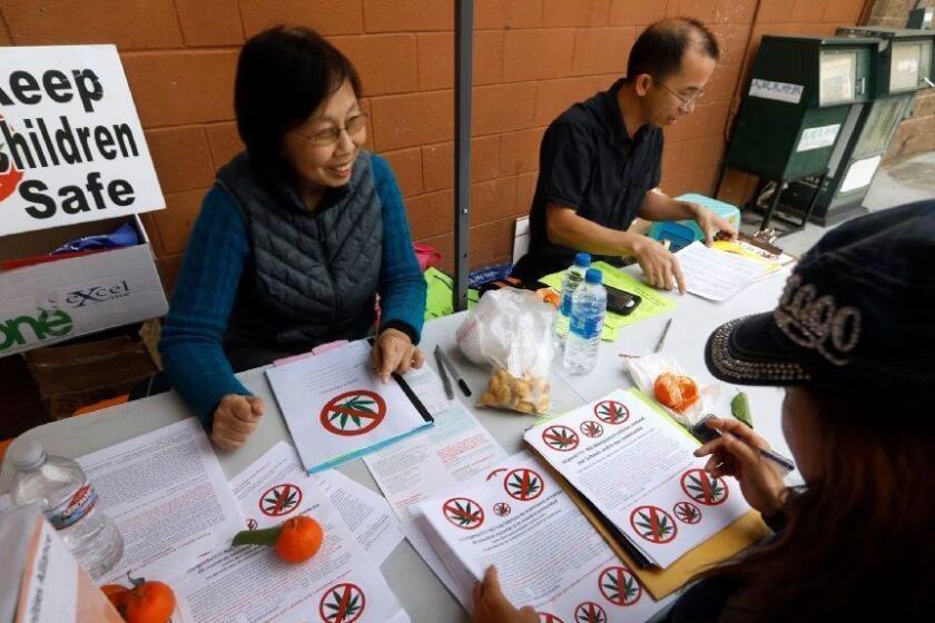 EL MONTE, CALIFORNIA--JAN. 29, 2019--Nancy Fang, left, of San Gabriel City, Zig Jiang, middle, of Hacienda Heights, and Lily Chan, of Temple City, right, prepare flyers to distribute in the area against the approval of future marijuana manufacturing sites. Many residents of El Monte are angry the first large facility to grow and process medical marijuana has been approved by the city council. A second is now under consideration. Many of the opponents are from the neighboring town of Temple City, zoned for residential housing. (Carolyn Cole/Los Angeles Times)