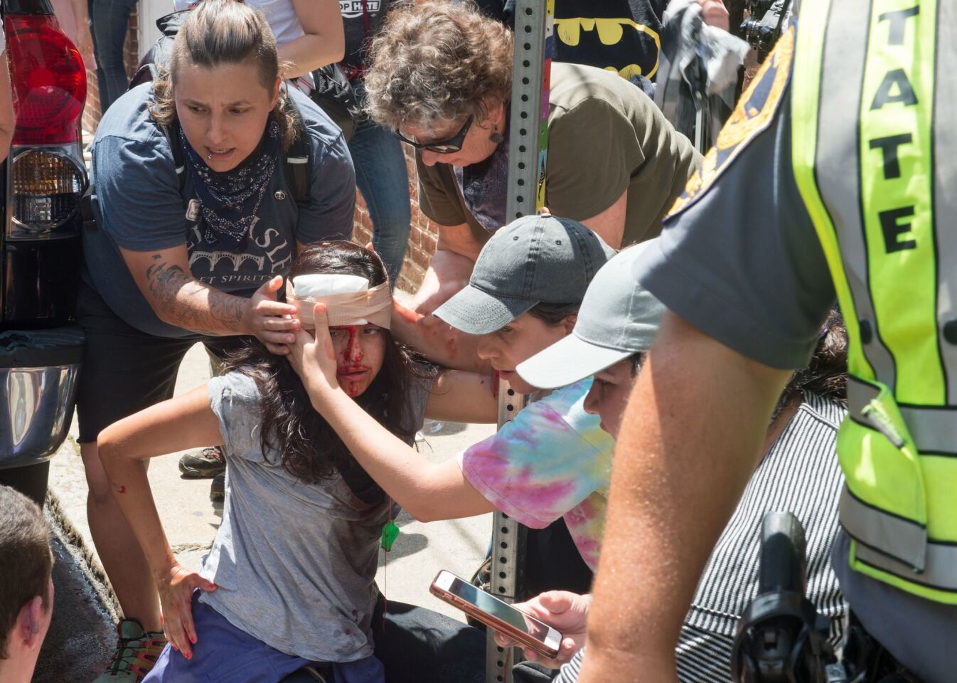 People receive first aid after a car plowed into a crowd of protesters in Charlottesville, Va.