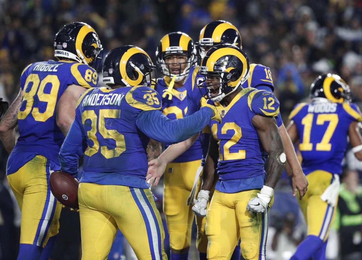 Rams running back C.J. Anderson (35) celebrates with receiver Brandin Cooks (12) and other teammates after he scored a touchdown on a fourth-down play during the fourth quarter.