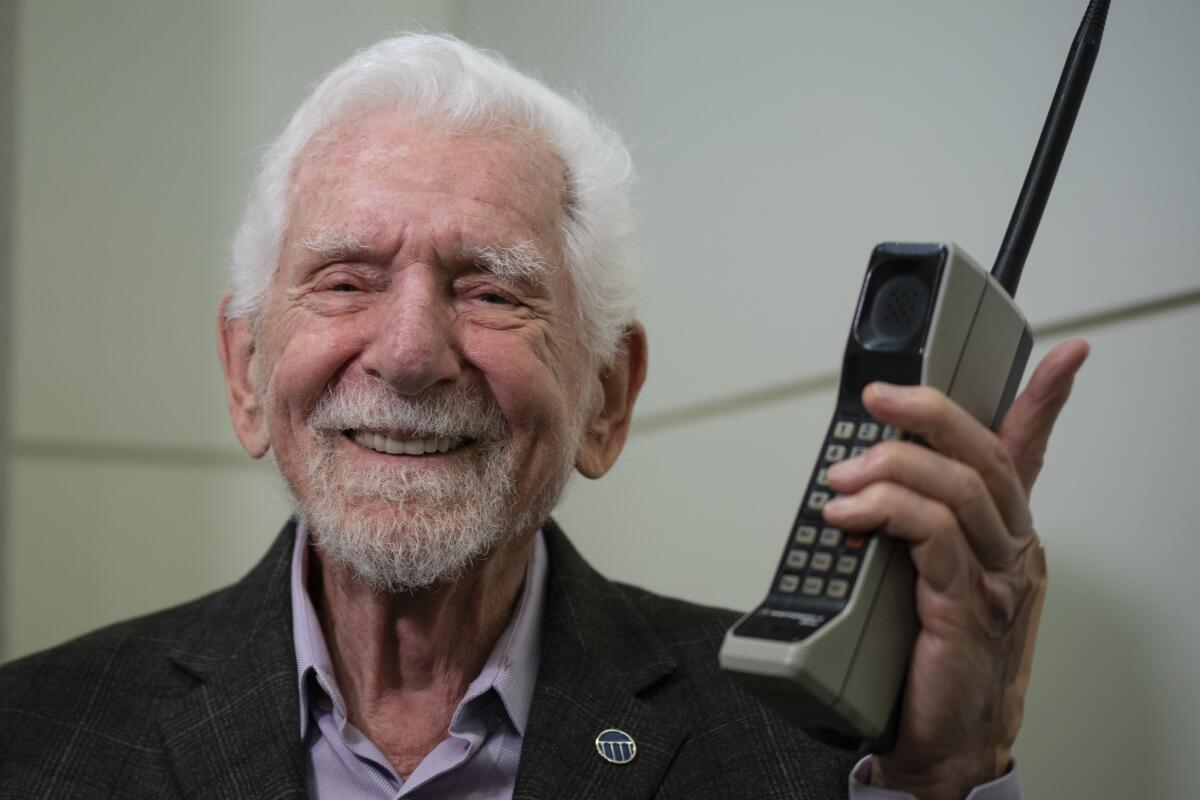 Marty Cooper, el inventor del primer teléfono móvil comercial, posa para la prensa con un Motorola 