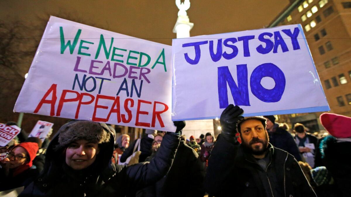 Demonstrators hold signs at a “Resist Trump” rally on Jan. 31 in the Brooklyn borough of New York. Liberals vowed to put pressure on Senate Minority Leader Chuck Schumer to mount a vigorous opposition to President Trump’s agenda.