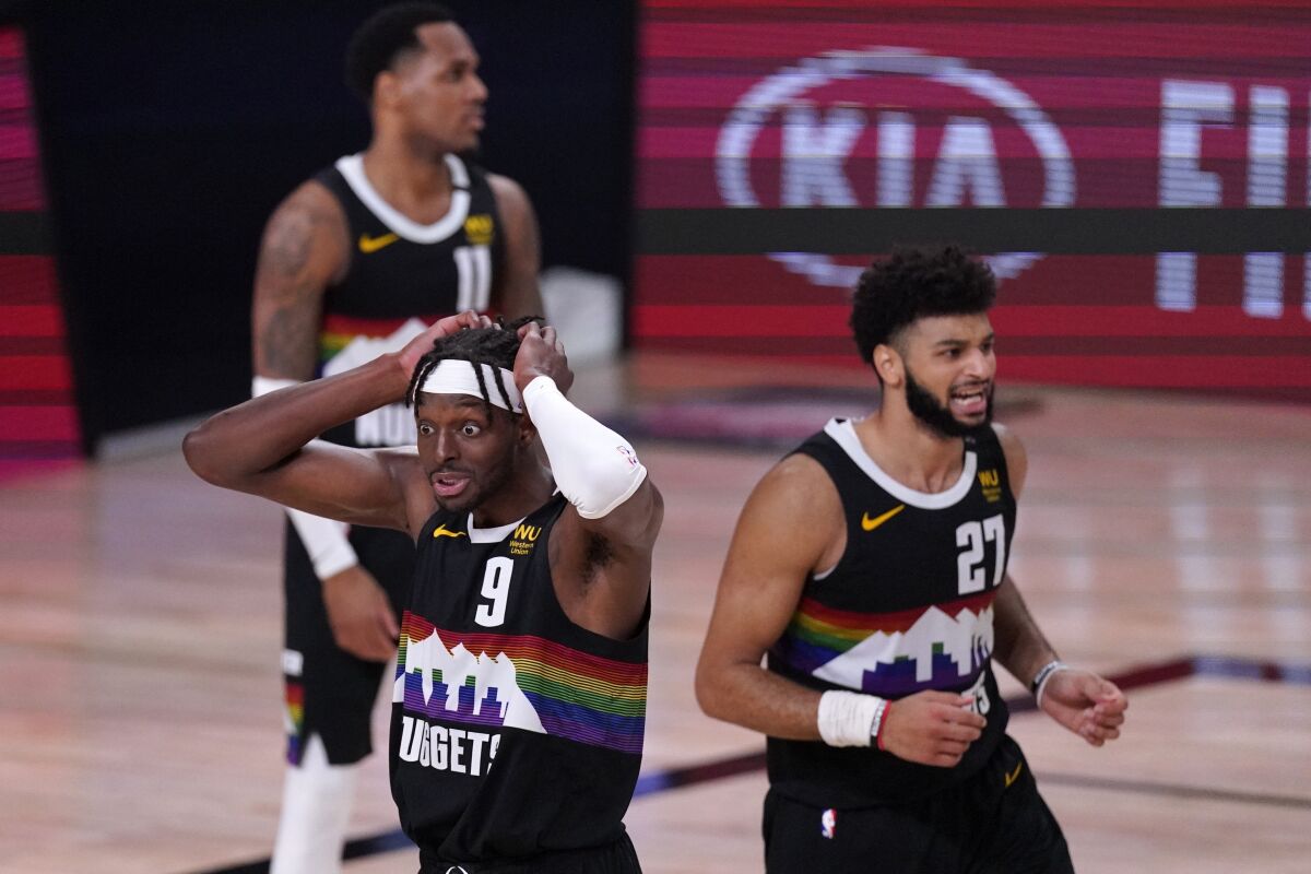 Nuggets forward Jerami Grant (9) and Jamal Murray react to a play during the Lakers' rally in the fourth quarter of Game 3.