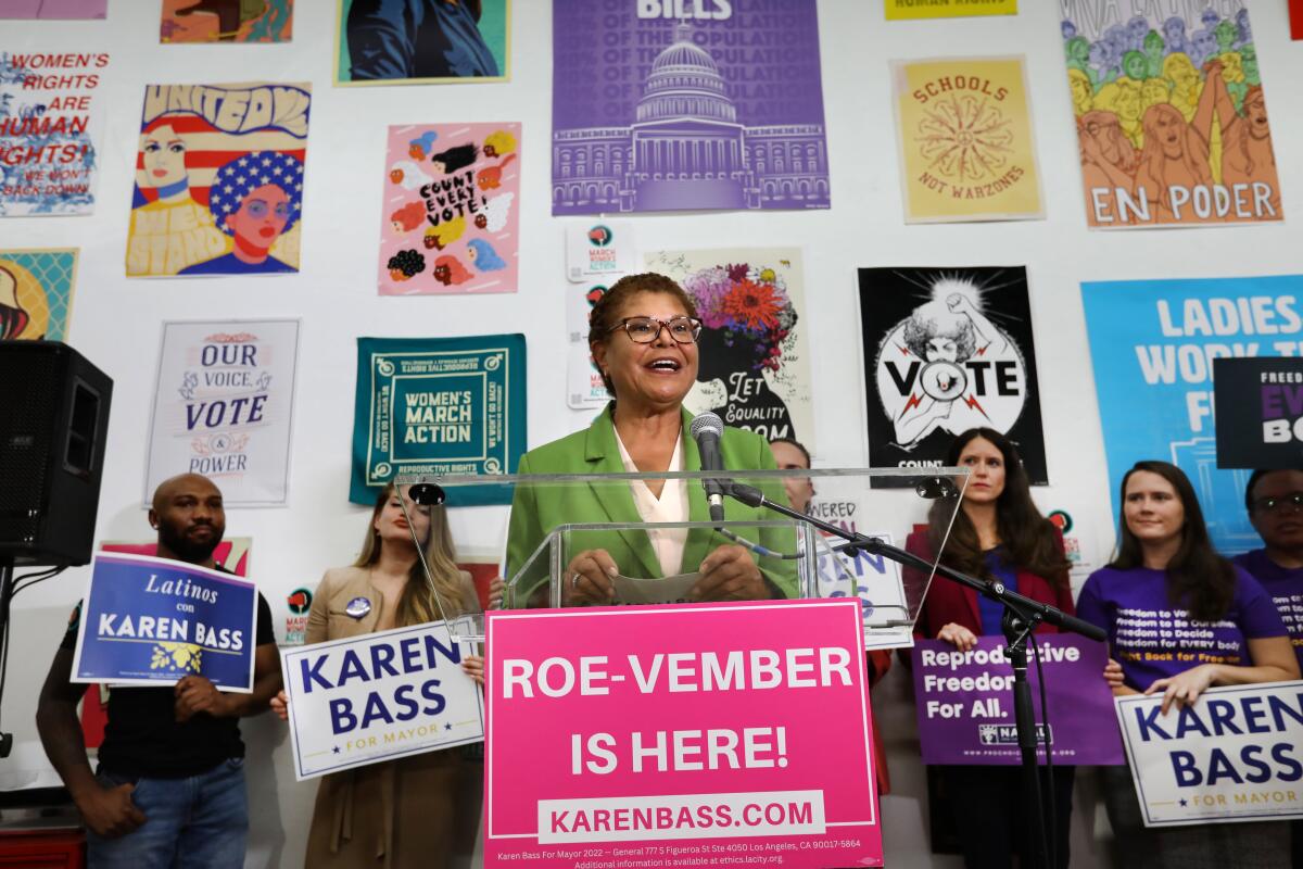 Rep. Karen Bass, center, speaking at a lectern