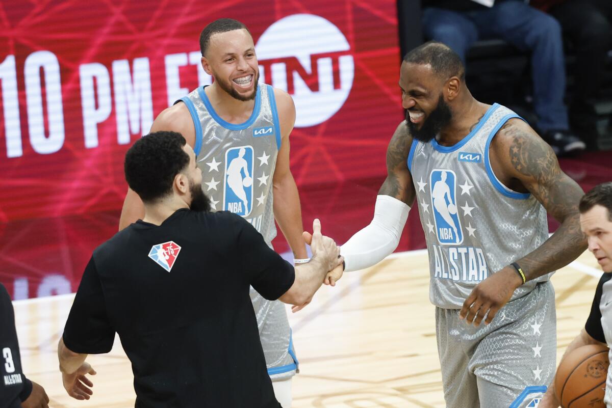 LeBron James, right, celebrates with teammates, including Stephen Curry after hitting the winning shot.