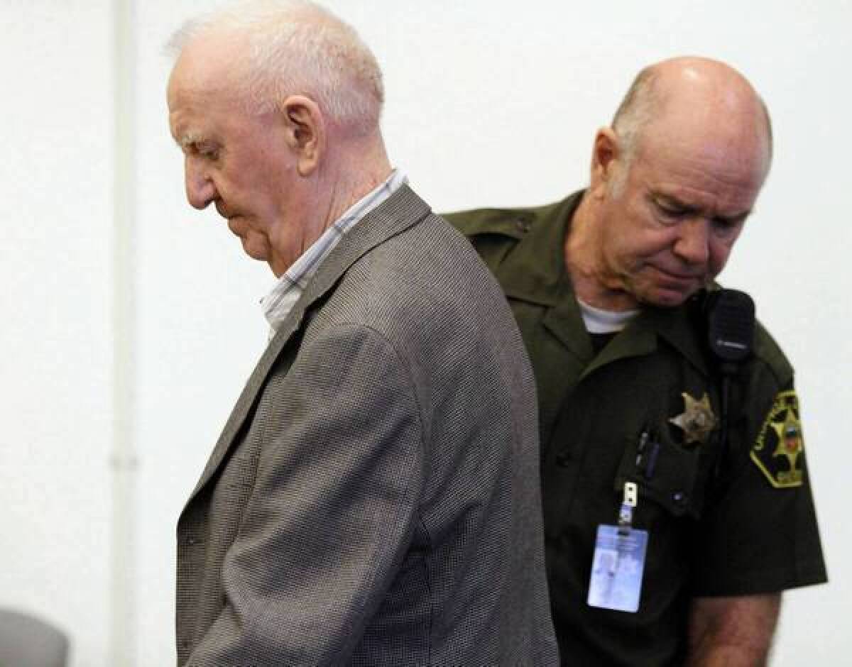 Retired Roman Catholic priest Denis Lyons, left, takes his seat in Santa Ana Superior Court for his sentencing hearing.