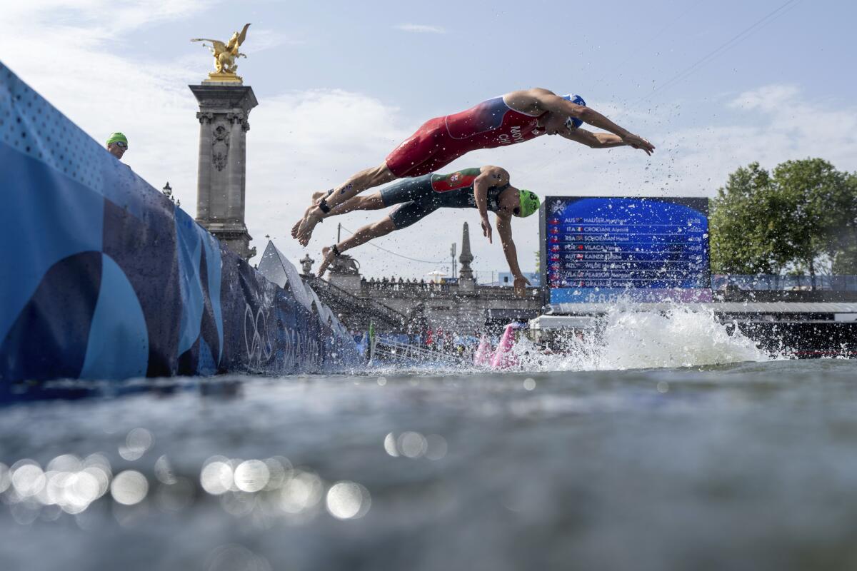 Chile's Diego Maya and Portugal's Vasco Vilaca dive back into the Seine River for the swim portion at the triathlon