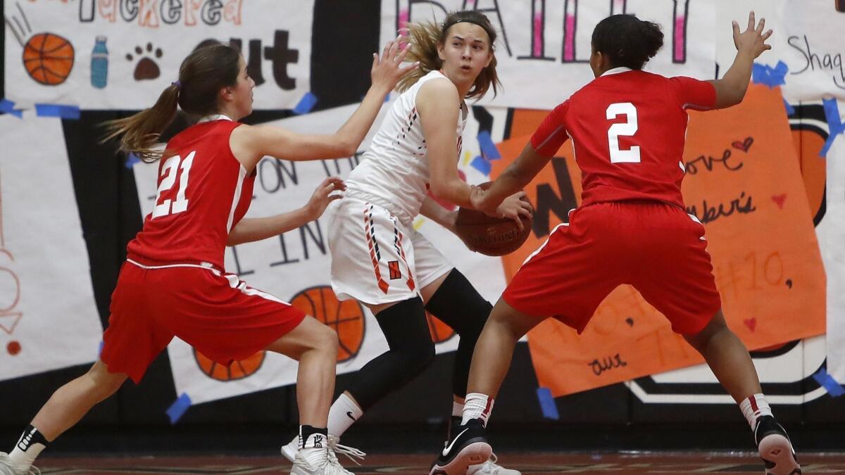 Huntington Beach High's Alyssa Real, seen getting trapped by Los Alamitos' Molly Clarke (21) and Asia Avinger (2) on Feb. 8, hit the game-winning three-pointer for the Oilers in a South Coast Classic pool-play game on Thursday.
