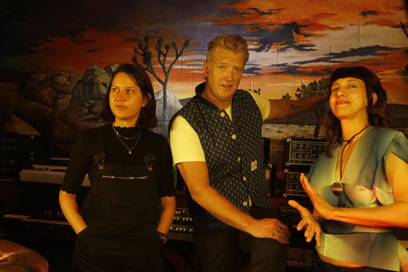 BURBANK, CA - OCTOBER 3, 2019 - - Drummer Stella Mozgawa, from left, of the band Warpaint, Josh Homme, with Queens of the Stone Age and drummer Carla Azar, of Autolux, right, contributed to the latest, “Desert Sessions,” album. They were photographed at the Pink Duck Studios in Burbank on October 3, 2019. Dormant since 2004, Desert Sessions is a recording project led by Josh Homme with a series of albums featuring collaborations with the likes of PJ Harvey, Ween, Mark Lanegan and many others in a small studio way out in the desert of Joshua Tree. Homme is about to release the first new Desert Sessions album in 15 years on Oct. 25, and includes songs recorded with Mozgawa, Azar, Billy Gibbons of ZZ Top and Les Claypool, among others. (Genaro Molina / Los Angeles Times)