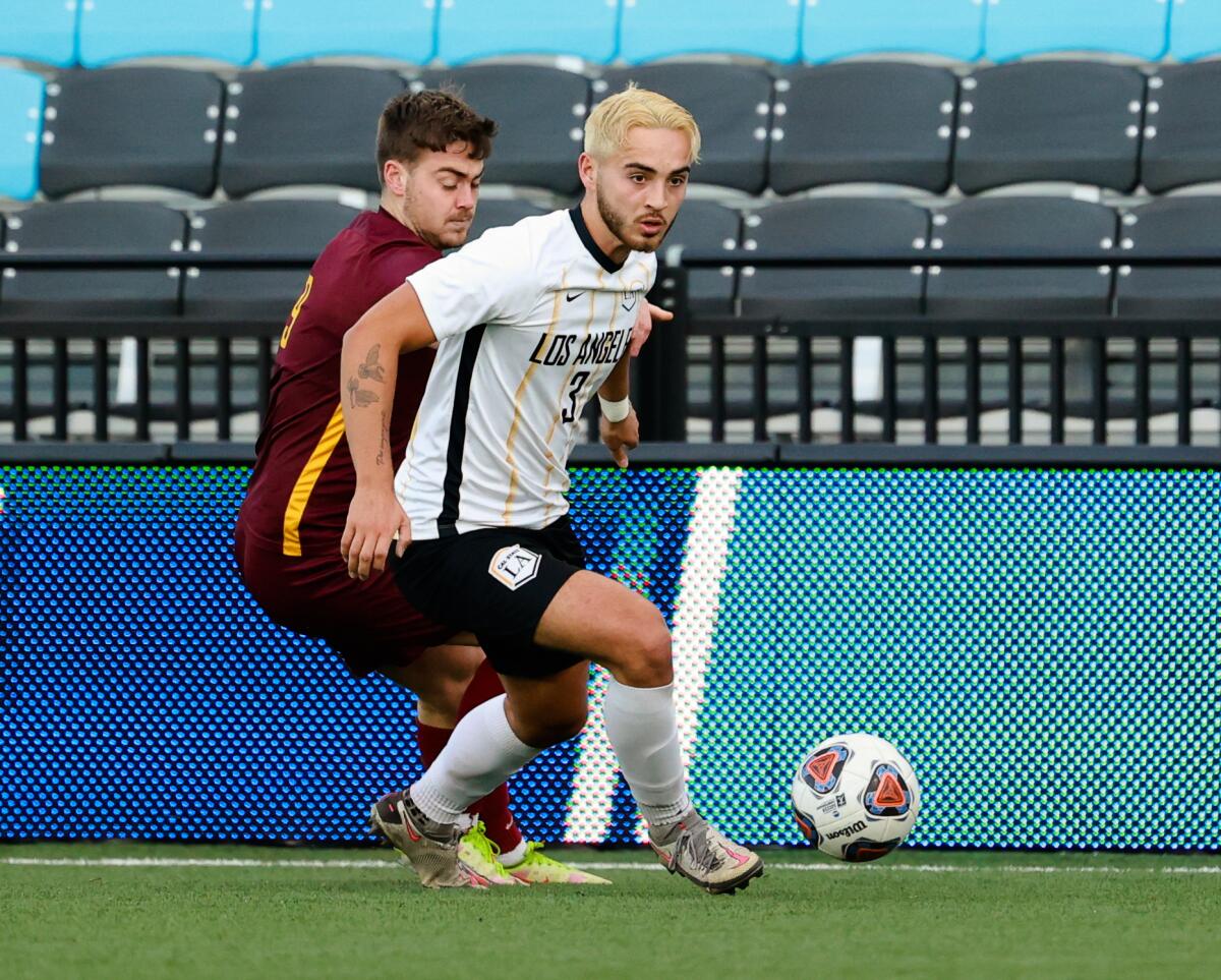 Simon Johansen, right, of the Cal State Golden Eagles is defended by Charleston's Alex Townley.