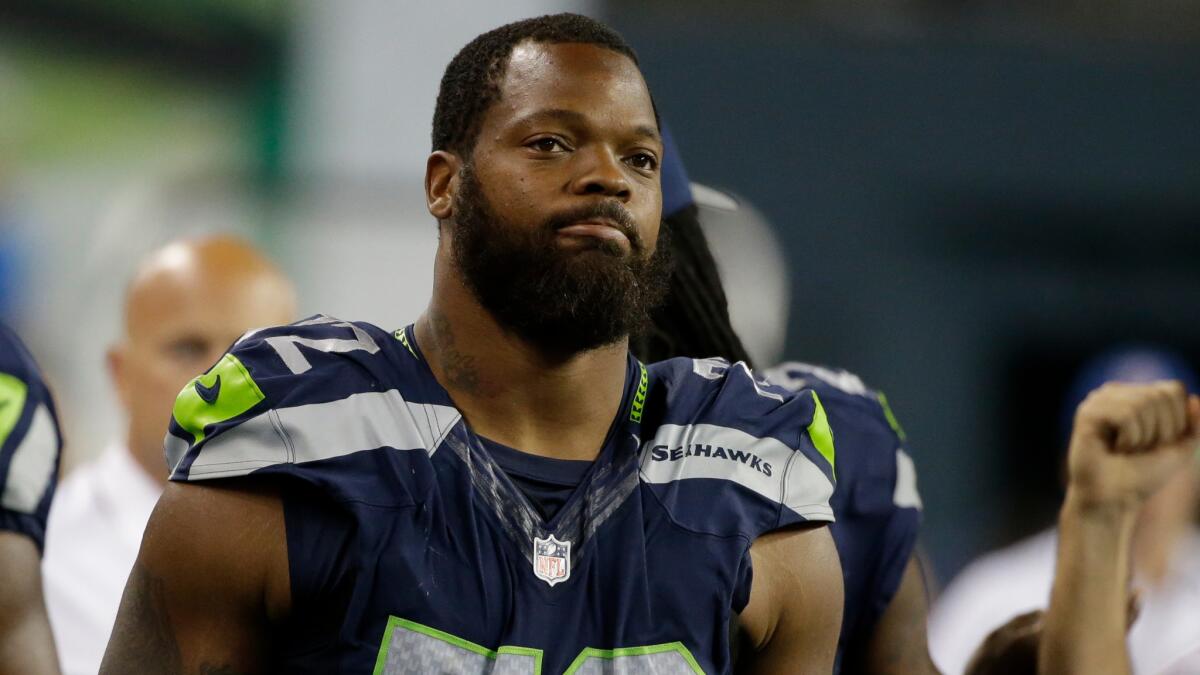 Seattle's Michael Bennett stands on the sidelines on Aug. 25.