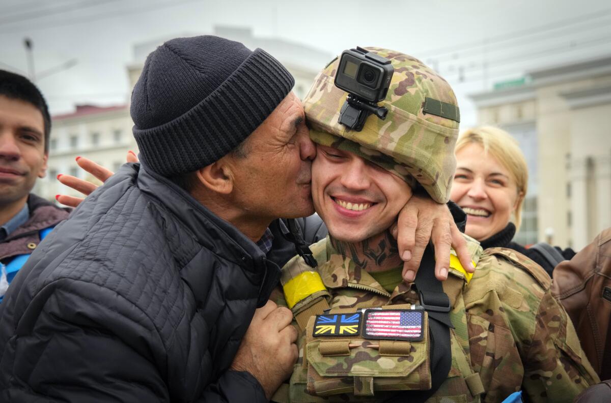 A Kherson resident kisses a Ukrainian soldier in central Kherson, Ukraine, Sunday, Nov. 13, 2022. The Russian retreat from Kherson marked a triumphant milestone in Ukraine's pushback against Moscow's invasion almost nine months ago. (AP Photo/Efrem Lukatsky)