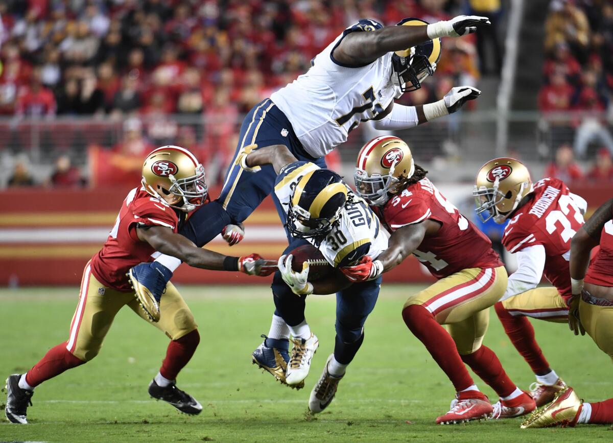 Rams running back Todd Gurley is brought down by the 49er defense as offensive lineman Greg Robinson tries to avoid him in the third quarter.