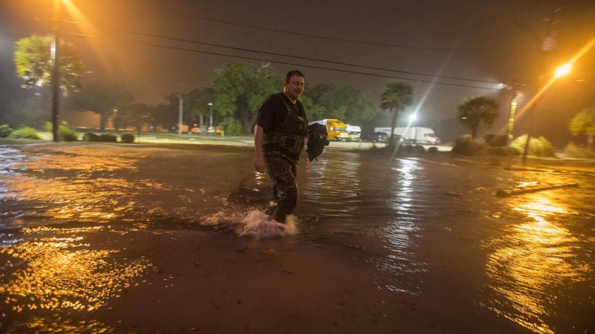 Lanny Dean of Tulsa, Okla., takes video as he wades along a flooded Beach Boulevard as the eye of Hurricane Nate pushes ashore in Biloxi, Miss.