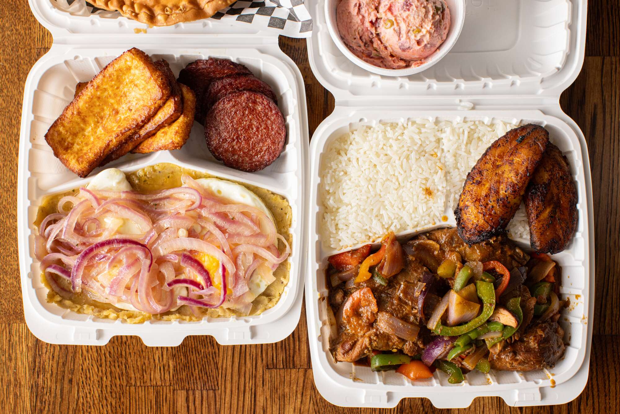 Takeout boxes with Dominican breakfast and chicken dishes.