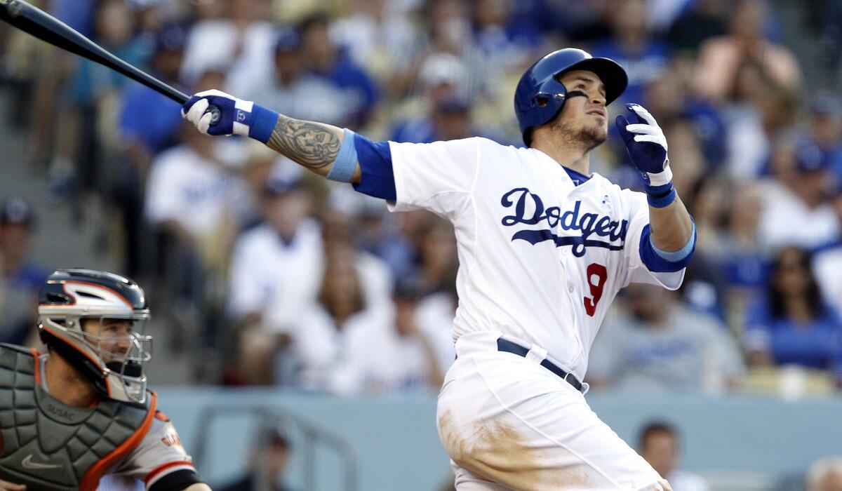 Los Angeles Dodgers’ Yasmani Grandal hits a solo home run with San Francisco Giants catcher Andrew Susac looking on during the fourth inning on Sunday. The Dodger rout the Giants, 10-2.