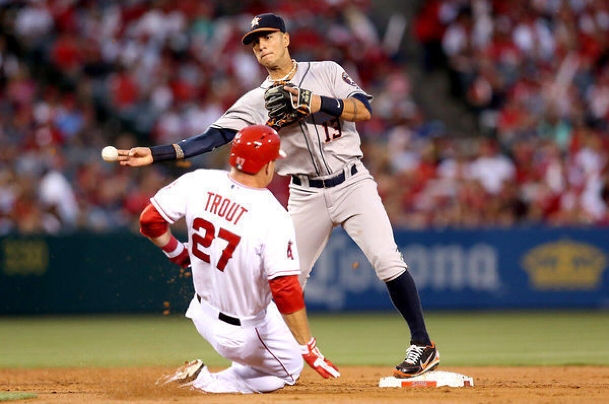 Houston Astros shortstop Ronny Cedeno throws to first to complete a double play after forcing out Angels' Mike Trout.
