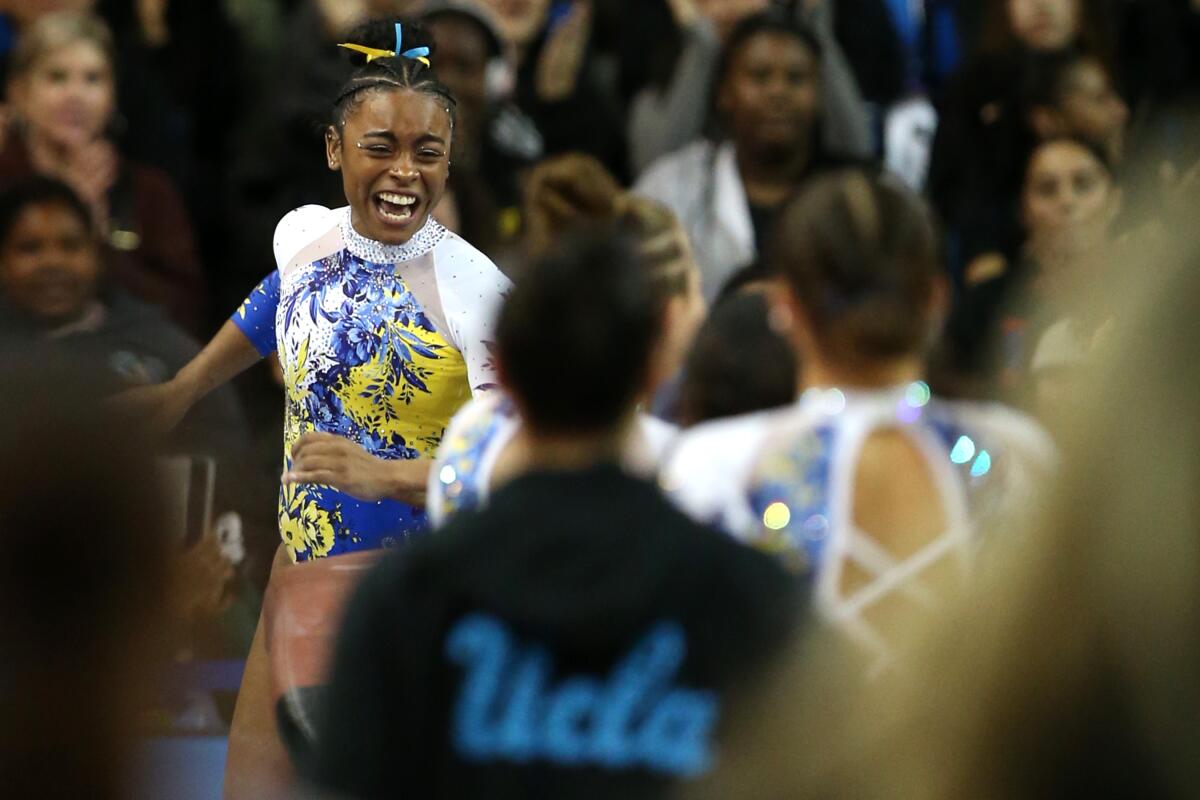 Selena Harris celebrates after earning a perfect score on vault during a dual meet.