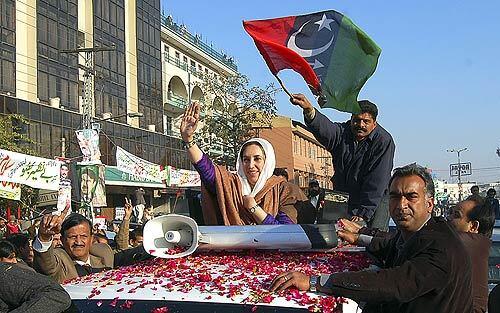 Benazir Bhutto waves to supporters Thursday at a public rally in Rawalpindi, Pakistan, where she gave what would be her last speech. The opposition leader was gunned down as her convoy pulled away from the event, and an explosion soon after the shooting charred her bullet-proof vehicle and killed at least 20 people. "I risked my life and came here because I believe our country is in danger," Bhutto told a crowd of flag-waving supporters at the rally.