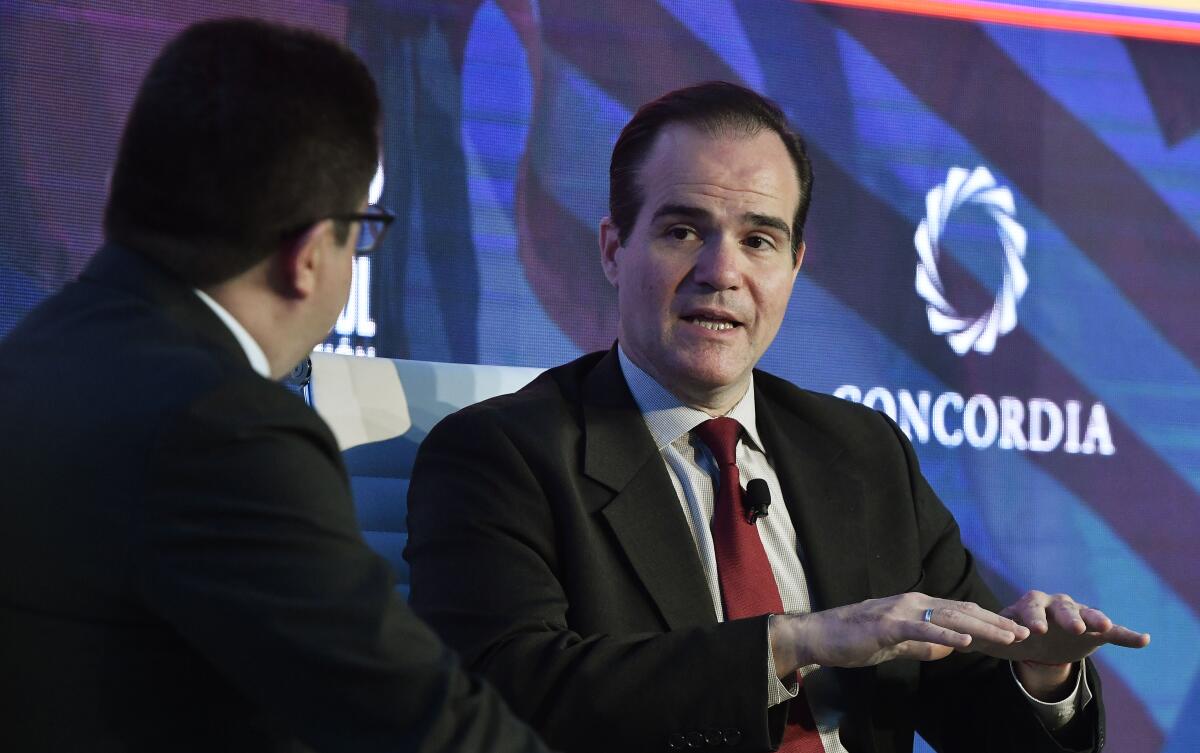 Caracol TV journalist Ricardo Ospina, left, and Mauricio Claver-Carone, senior director at the National Security Council.
