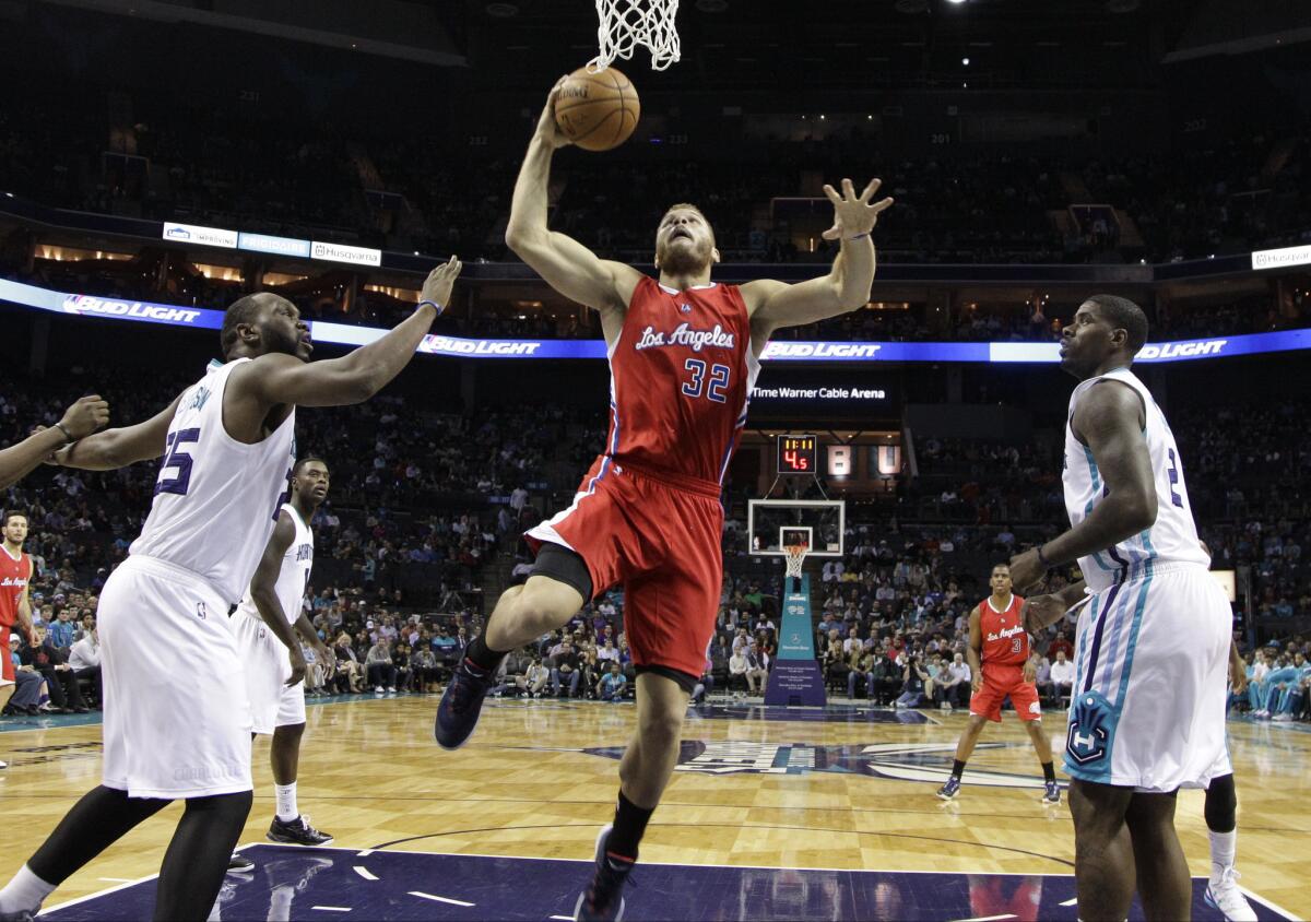 The Clippers' Blake Griffin drives between Charlotte's Al Jefferson, left, and Marvin Williams on Monday.