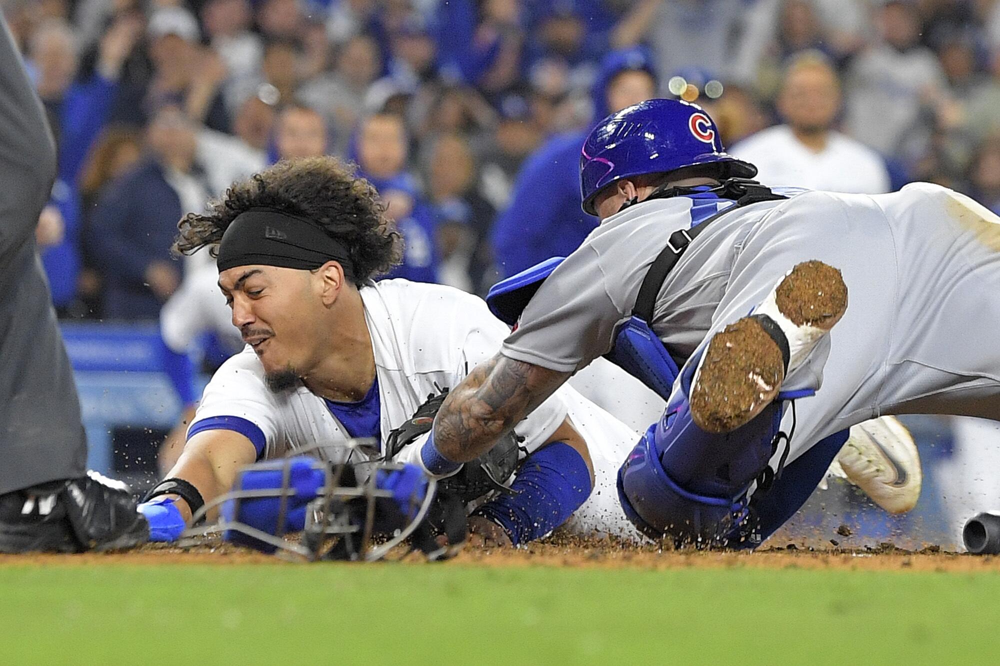 Miguel Vargas, left, slides into home plate to score the winning run in the Dodgers' 2-1 walk-off victory Saturday night.