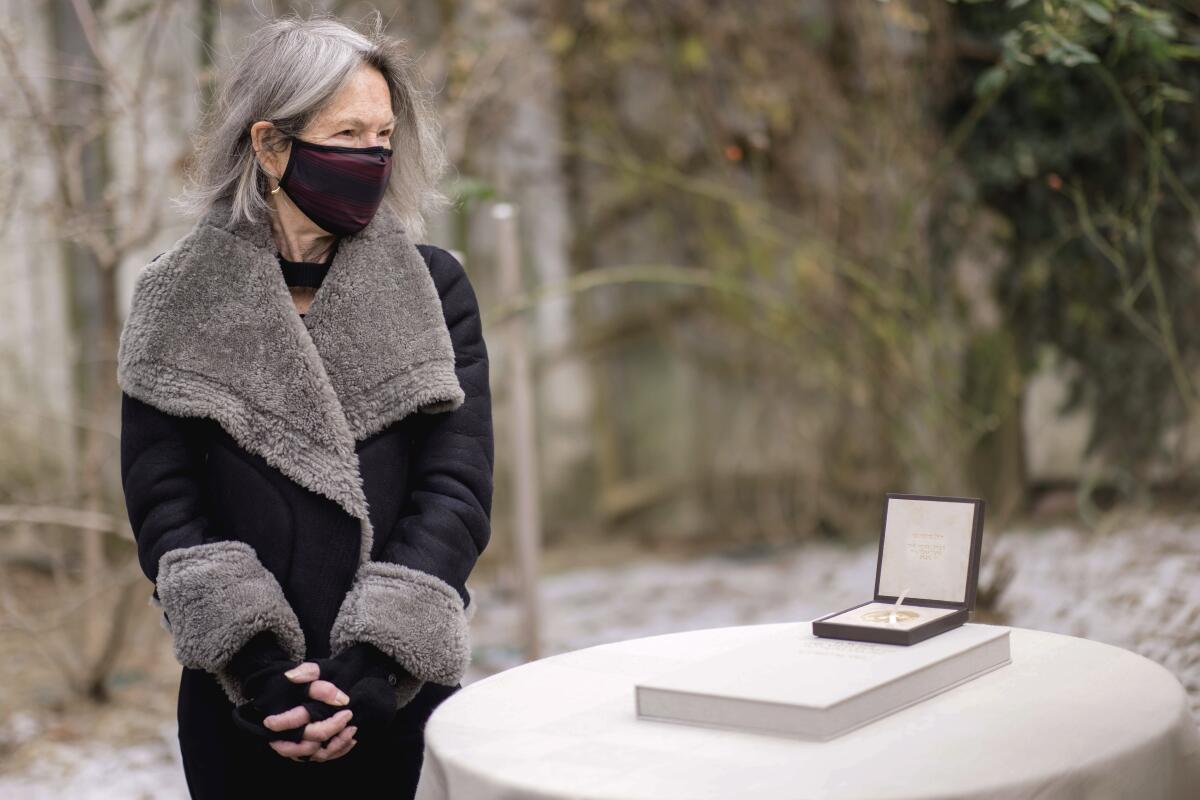 American poet Louise Glück is awarded the Nobel Prize in literature at her home Sunday in Cambridge, Mass.