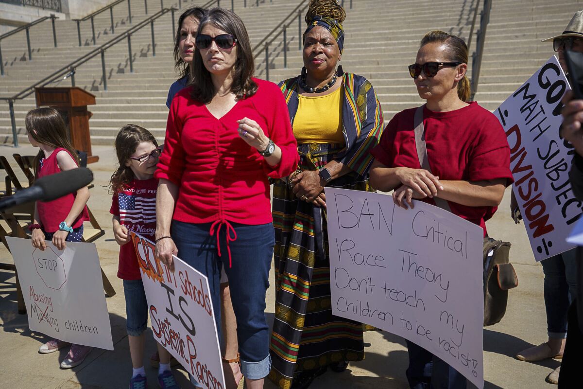 Mothers and children carry signs about critical race theory at a Utah rally.