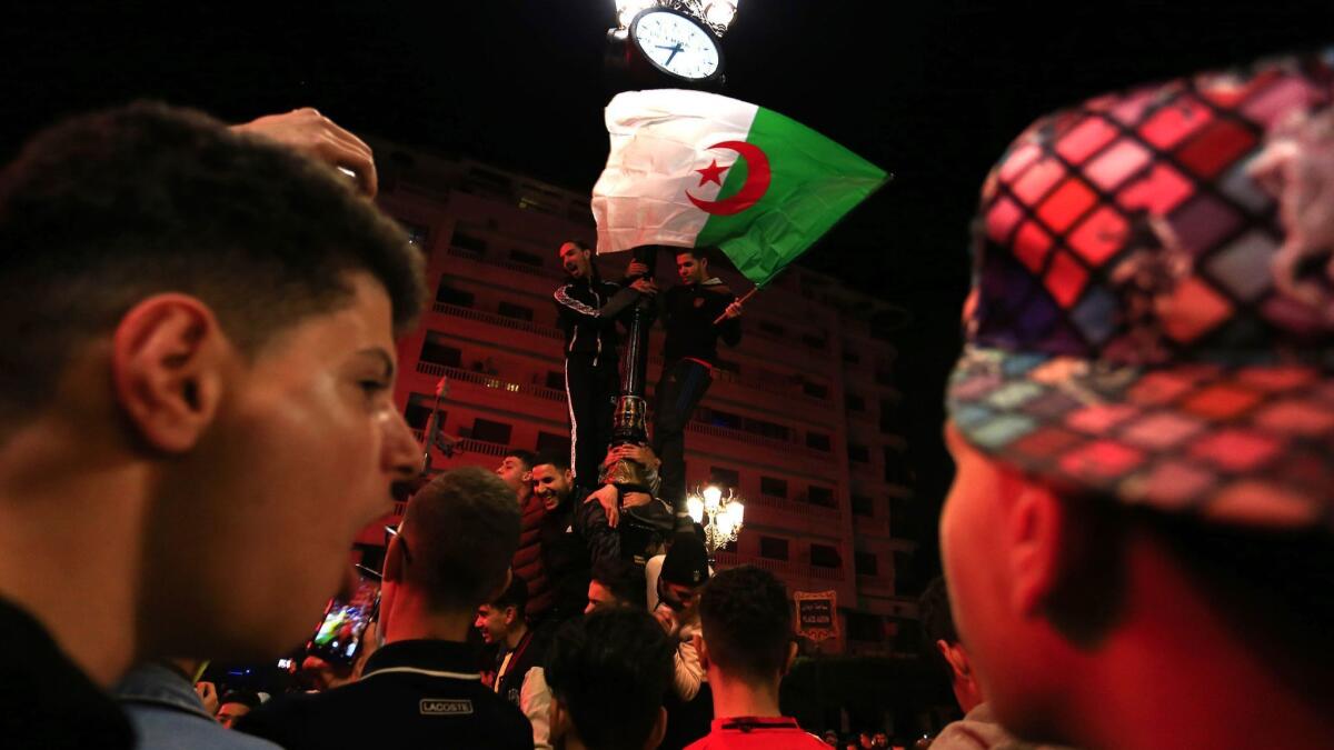 Algerians celebrate in Algiers, the capital, on Monday after President Abdelaziz Bouteflika announced he is delaying the April 18 election and won't seek a fifth term.