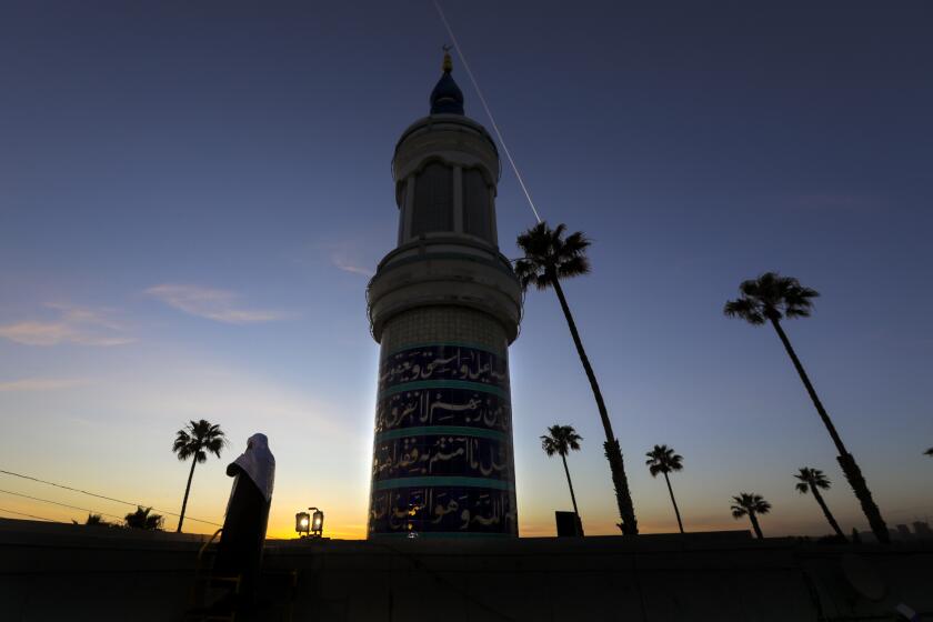 CULVER CITY, CA - MAY 16: Mahmood Nadvi (Cq), left, standing on the rooftop, delivers Islamic call to prayers Adhan, summoning Muslims for obligatory prayers, at King Fahad Mosque in Culver City. In the midst of pandemic lockdown many mosques in Southern California got permission from local authorities to broadcast Adhan. in King Fahad Mosque on Saturday, May 16, 2020 in Culver City, CA. (Irfan Khan / Los Angeles Times)