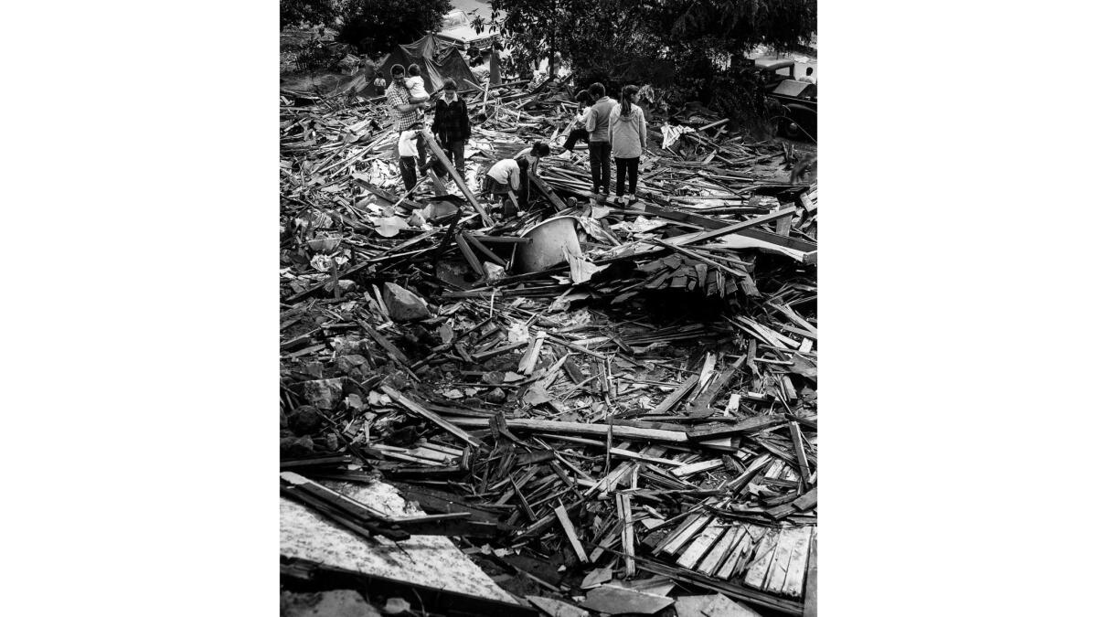 May 10, 1959: Mike Angustian, 32, holds his son, Ira, as he and his wife, Victoria, 29, their children and children of Victoria's sister, Aurora Fernandez, looked for personal belongings in rubble that was their home in Chavez Ravine.