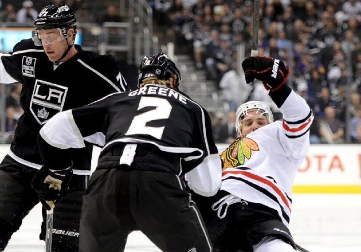 Kings' Matt Greene checks the Blackhawks' Patrick Sharp