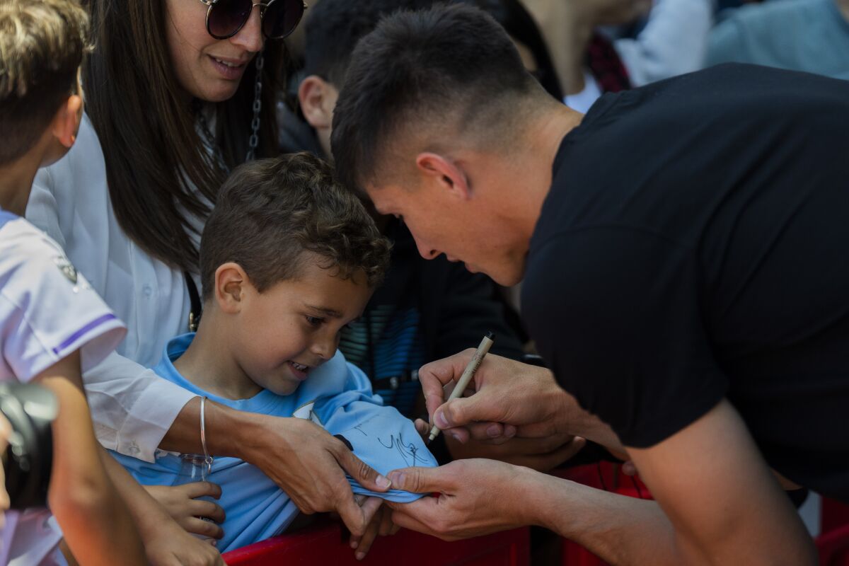 El portero uruguayo Sergio Rochet autografía la camiseta de un chico 